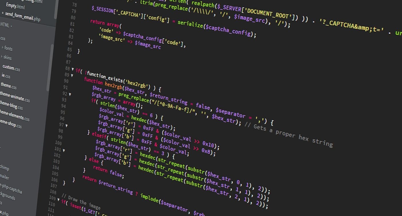 A developer workstation with a glowing monitor showing code, neon-lit and focused